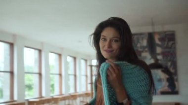 Genç, güzel, gülümseyen Avrupalı uzun saçlı esmer kız mavi hastalıklı eşarba dokunarak içeri girdi.