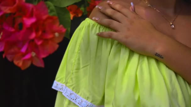 一个黑头发的年轻姑娘站在后院摸着一条带白点的黄色连衣裙 — 图库视频影像