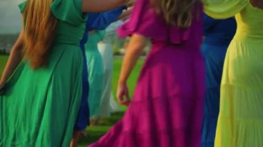 Bir grup Avrupalı genç kız el ele tutuşarak ve bir tünel içinde koşarak doğada bir oyun oynuyorlar.