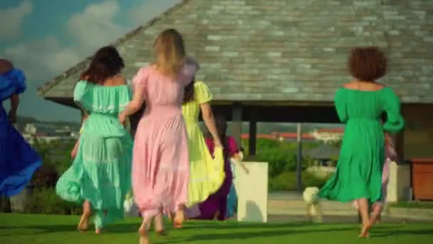 緑の芝生の上で裸足で前に走っている長いドレスの若いヨーロッパの女の子の背中 — ストック動画
