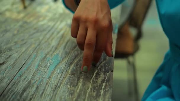 一个年轻的欧洲姑娘坐在一张木制桌子旁 手指放在桌子上玩 就像这个走起路来的男人 — 图库视频影像
