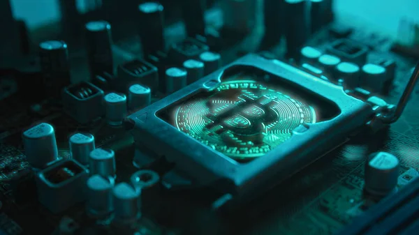 Karanlıkta mavi ışığı olan elektronik bileşenleri olan bir ana kartta merkezi işlemci yerine parlayan ve yansıtan altın bir Bitcoin. Bitcoin madenciliği.