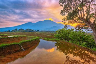 Bengkulu, Endonezya 'da sabah güneş doğarken dağların ve gökyüzünün yansıması.