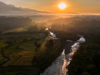 Endonezya 'da güzel bir sabah manzarası, dağ sıraları ve açık gökyüzü olan pirinç tarlalarının panoramik manzarası