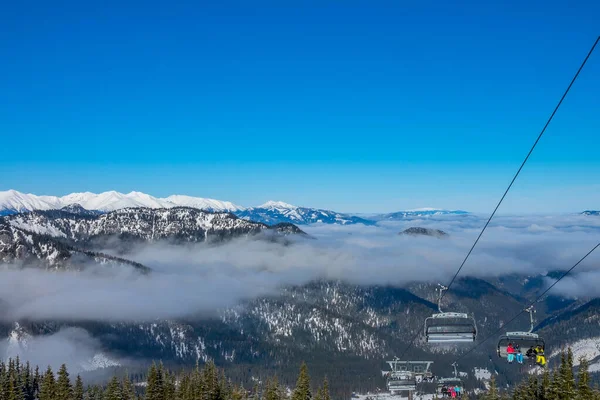 在Jasna的斯洛伐克滑雪胜地 蓝天和薄雾夹在山巅之间 雪在阳光下闪闪发光 椅子滑雪升降 — 图库照片