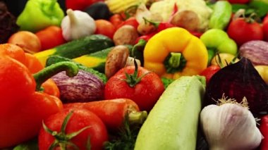 Yakın plan taze sebzeler: lahana, havuç, mısır, salatalık, sarımsak, soğan, biber, patates, salata, domates, mantar. Kamera yavaş hareket ediyor.