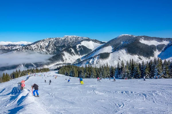 冬天的山天气晴朗时 滑雪场又宽又软 很多滑雪者 山谷中的薄雾 — 图库照片