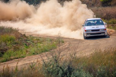 Güneşli bir yaz günü. Tozlu rali pisti. Spor araba 01 numaralı virajda çok toz yapıyor.