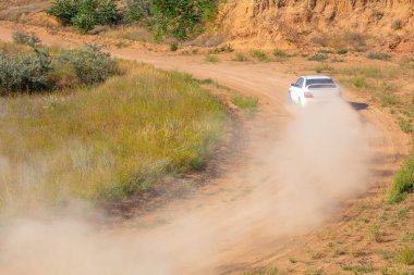 Güneşli bir yaz günü. Tozlu rali pisti. Spor araba sırasıyla 03 'te çok toz yapıyor.