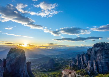 Yunan Meteora 'sında yaz günbatımı. UNESCO tarafından listelenen kayalıklarda bir manastır.