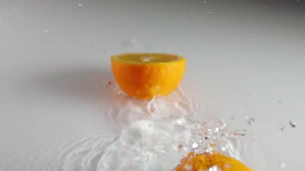 Λευκό Τραπέζι Και Ένα Λεπτό Στρώμα Νερού Ώριμο Πορτοκάλι Πέφτει — Αρχείο Βίντεο