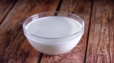 Tahta bir masanın üzerinde cam bir kase süt duruyor. Yaban mersini düşer ve bir sürü sıçrama yaratır. Yavaş çekim