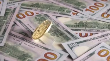 Bir sürü 100 dolarlık banknot tüm masayı kapsıyor. Bitcoin merkezde döner. Yavaş çekim