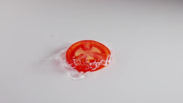 Strato Sottile Acqua Tavolo Bianco Una Fetta Pomodoro Succoso Cade — Video Stock