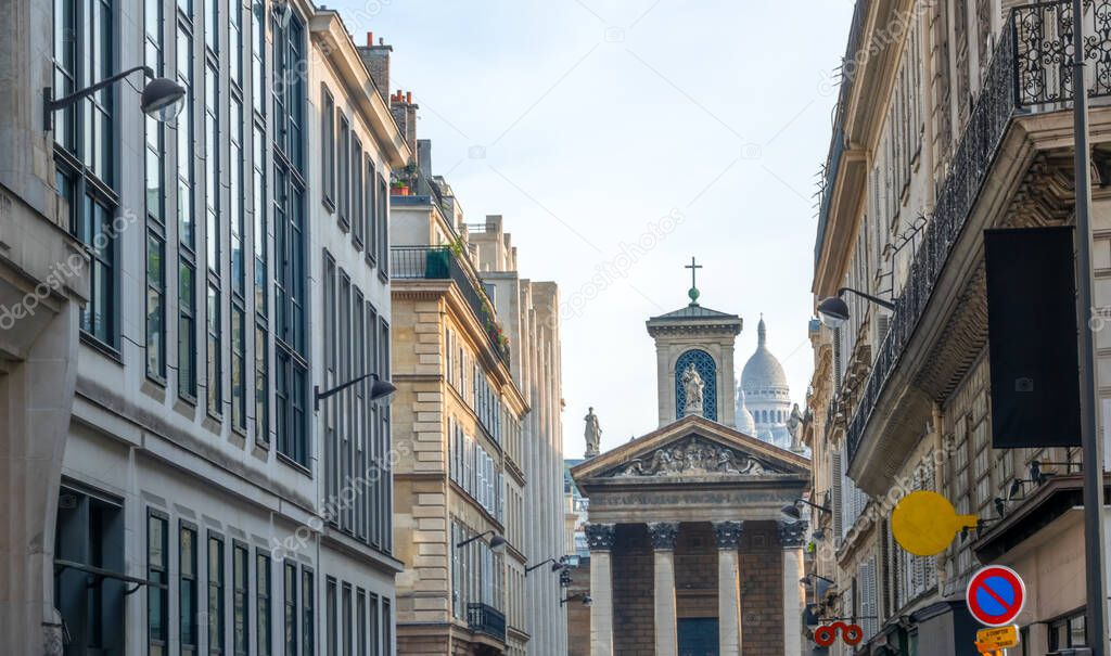 France. Summer day in Paris. Cathedral with columns at the end of a narrow street