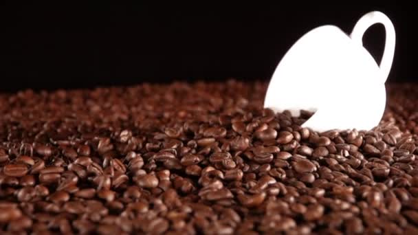 Dużo Ziarna Kawy Stole Biały Kubek Czarne Tło Kilka Fasoli — Wideo stockowe