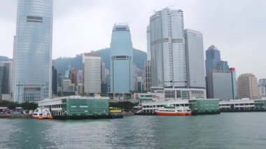 Hong Kong - 28 Nisan 2016: Hong Kong gökdelenleri üzerinde bulutlu hava. Feribottaki kamera yolcu iskelesine doğru yüzüyor.