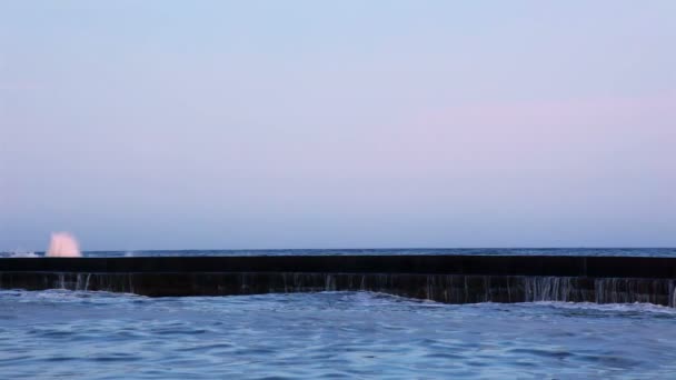 Vague de surf sur le brise-lames au coucher du soleil. Mouvement lent — Video