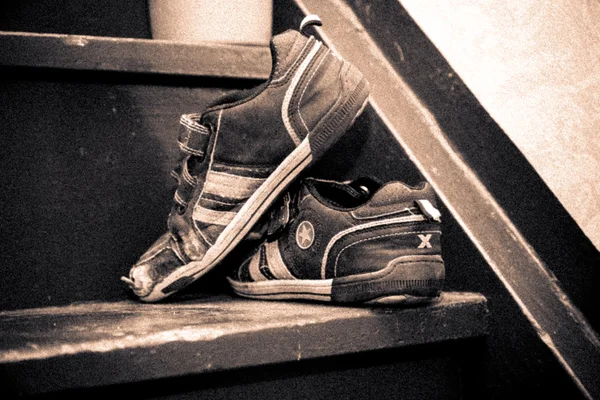Bir merdiven üzerinde eski çocuk ayakkabı