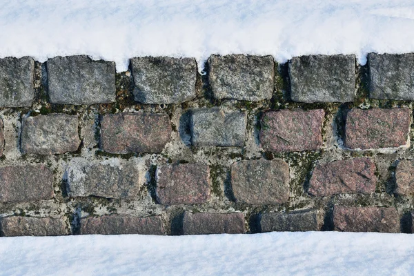 Antico muro di pietra nella neve — Foto Stock