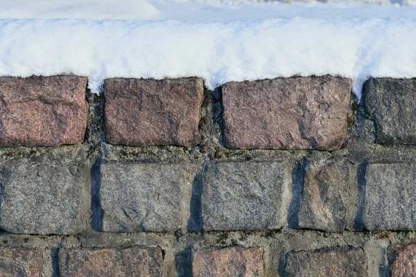 Vecchio muro di pietra nella neve — Foto Stock