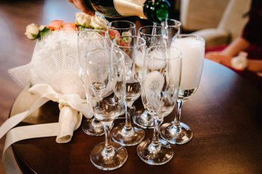 Garson masaya şampanya bardakları dolduruyor. Parti ve tatil kutlaması konsepti.