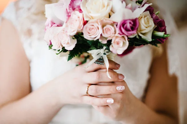 Bride\'s bouquet in hands. Wedding rings bride. Engagement.