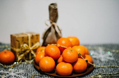 Tabakta mandalina, hediye kutusu, kar taneleri ve gri örülmüş arka planda kırsal stil çuvalı. Metin ve tasarım için boşluk. Kutlama kartı mı? Mutlu Noeller, mutlu yıllar 2018 Kutlama Kavramı.