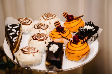 Tatlı, lezzetli çikolatalı ve vanilyalı kekler, arka planda bir tabakta, tatlı, fırınlanmış bir masa..