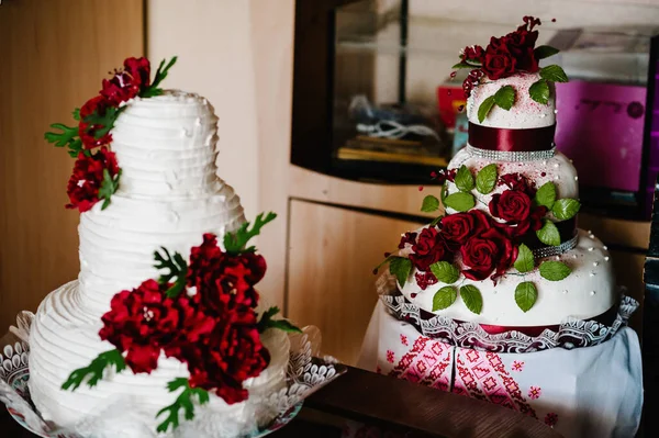 A delicious sweet wedding loaf, cake in the Ukrainian style on embroidered towels. Festive sweet table.