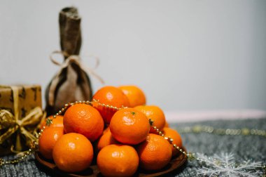 Tabakta mandalina, hediye kutusu, kar taneleri ve gri örülmüş arka planda kırsal stil çuvalı. Metin ve tasarım için boşluk. Kutlama kartı mı? Mutlu Noeller, mutlu yıllar 2018 Kutlama Kavramı.