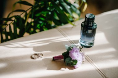 Tasarımcı Silver iki alyans, parfüm şişesi ve arka planda fotokopi alanı olan çiçekler. Nişan. Lüks evlilik ve düğün aksesuarı konsepti.