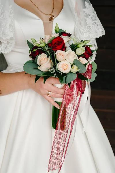 穿着雅致衣服的年轻漂亮的姑娘正站在那里 手里拿着一束束带彩带的油腻花束和绿叶 新娘在户外举行婚礼 — 图库照片