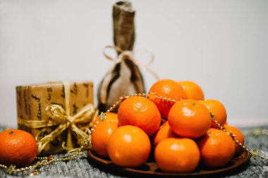 Tabakta mandalina, hediye kutusu, kar taneleri ve gri örülmüş arka planda kırsal stil çuvalı. Metin ve tasarım için boşluk. Kutlama kartı mı? Mutlu Noeller, mutlu yıllar 2019 Kutlama Kavramı.