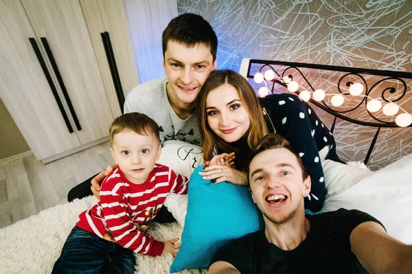 클로스 스웨터를 크리스마스 이브에 가족과 친구들은 셀카를 만들고 집에서 침대에서 — 스톡 사진