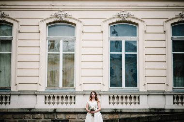 Portre gelini dışarıdaki eski binanın yanında duruyor, klasik saray açık havada..
