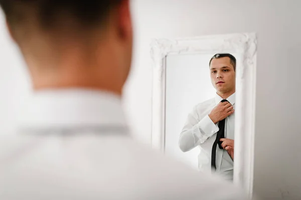 这个人看着镜子里自己的倒影 在家里把领带系在衬衫上 服装概念 — 图库照片