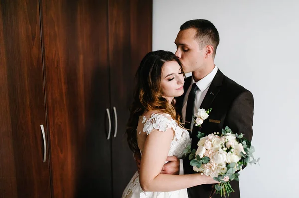 Noivo Terno Beijando Noiva Vestido Branco Estão Segurando Belo Buquê — Fotografia de Stock