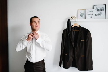 Evdeki erkek gömleği. Gömleğinin düğmelerini bağlayan adam. giyim konsepti.