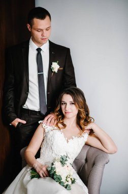 Gelin ve damadın klasik portresi odanın arka planında. Mutlu günler genç çift. Tatil ve aile içinde aşk kavramı. Düğün tatilleri.