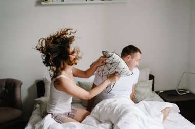 Aşk çifti yatakta yatan yastıklardan daha iyidir. Tatmin olmuş ve mutlu bir kadın kocasıyla birlikte atlıyor. Mutluluk duyguları güzel genç bir çift. Yaşam tarzı. Birlikte vakit geçirmenin tadını çıkarıyorum. Seni seviyorum..