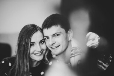 Noel ağacının yanında birbirine aşık bir çift. Bir kızla birlikte bir oğlan Noel 'i kutluyor ve sıcak bir evde Noel arifesinde birlikte eğleniyor. Yeni yılın aşk hikayesi. Siyah beyaz fotoğraf.