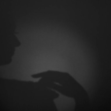 Sanat eserleri, gürültü, tahıl. Arka plandaki gri grunge 'da bir kadının gölgesi. Yan görüş. Siyah beyaz fotoğraf.