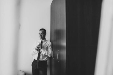 Sanat eserleri, gürültü, tahıl. Bir adamın gölgesi. Portre genç ve çekici damat aynada duruyor. Odadaki aynada yansıyan vücut. Siyah beyaz fotoğraf. Düğün Sabahı.