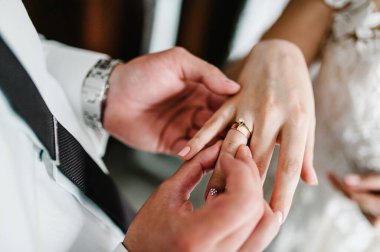 Damadın elleri gelinin parmağına nişan yüzüğü takar. Hazırlıklar. Düğün töreni. Mücevherler. Kapat..