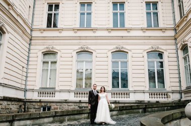 Antik mimarinin yanındaki güzel portre düğün çifti, eski bina, dışarıdaki eski ev, dışarıdaki klasik saray. Klasik atmosfer sokağında romantik aşk.