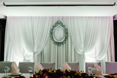 Şölen masası, kemer, ziyafet salonunda dekore edilmiş duvar. Yeni evliler düğün ziyafeti alanında toplandı..