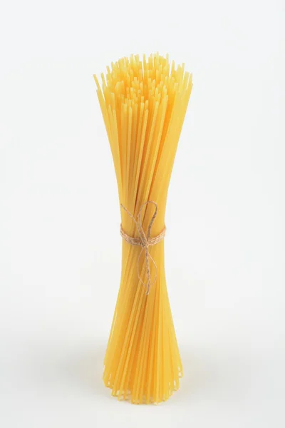 Espaguetis crudos sobre fondo blanco — Foto de Stock