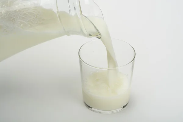 Melk in een glas gieten — Stockfoto