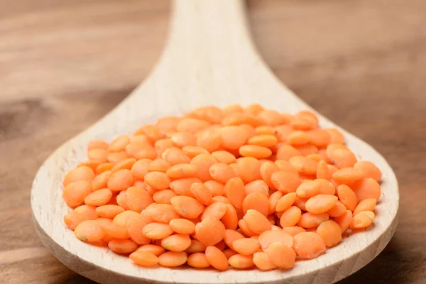 木製のスプーンで生のオレンジレンズ豆 — ストック写真
